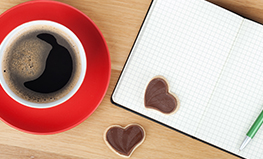 Red mug of coffee with heart-shaped cookies