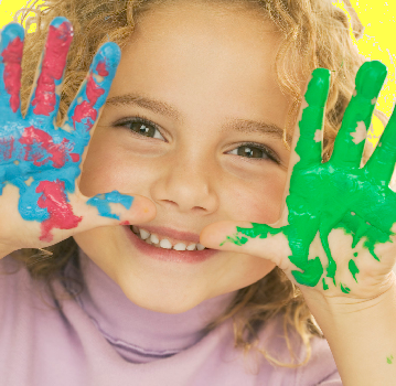 Happy preschooler holding up painted hands