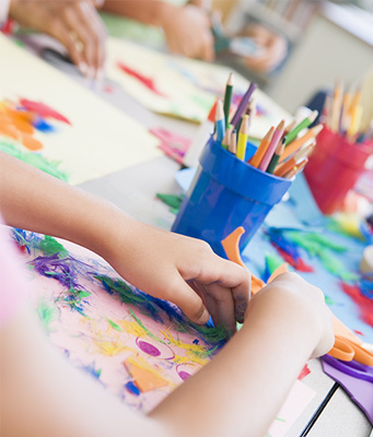 kids hands at an art table