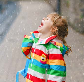 little girl catching raindrops on her tongue